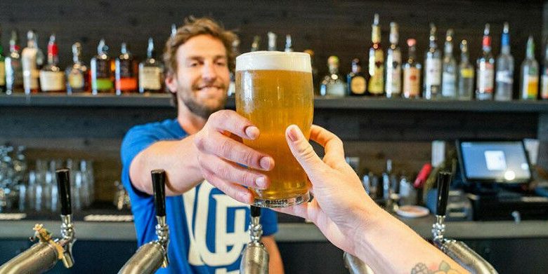 Barman entregando uma caneca de cerveja a um cliente Crédito: ELEVATE (Pexels)