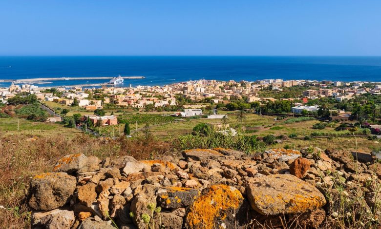 Uma visão ampla de edifícios e grama em uma ilha com vista para o oceano