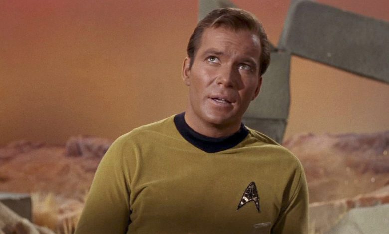 Uma captura de tela de um episódio de Star Trek mostrando William Shatner como Capitão James T. Kirk usando o icônico distintivo da Frota Estelar