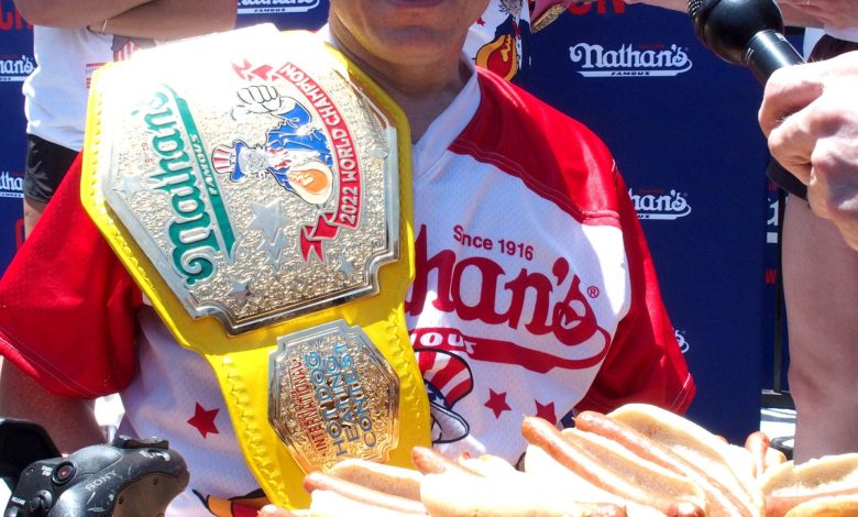 Joey Chestnut segurando um prato de cachorro-quente