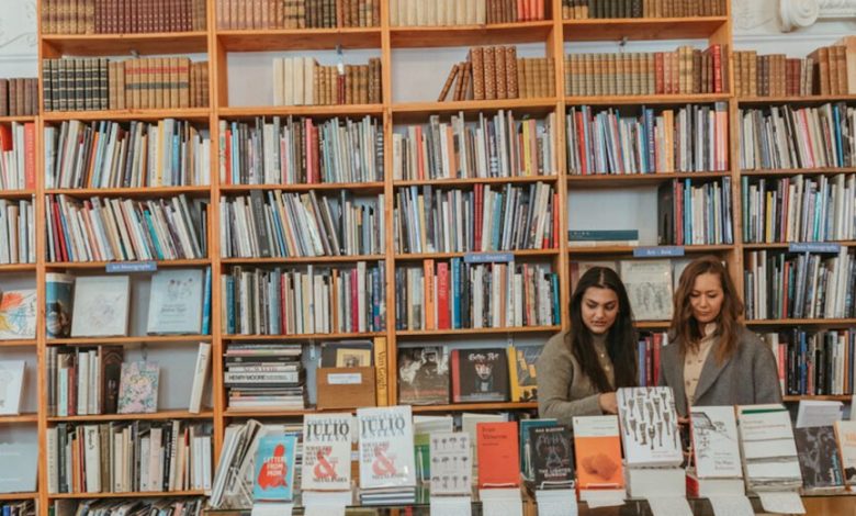 Mulheres romantizando o outono folheando uma livraria.