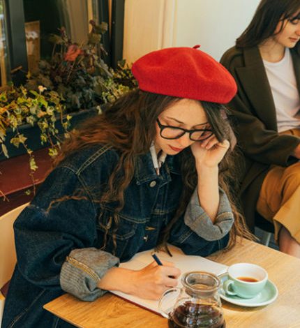 mulher escrevendo um diário em um café