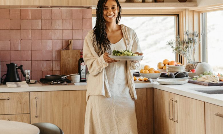 Mulher segurando comida na cozinha sincronizando receitas com o ciclo.