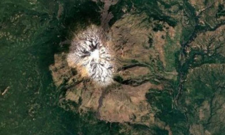 vista aérea do Monte Adams, no estado de Washington, com pico coberto de gelo e vegetação verde ao redor