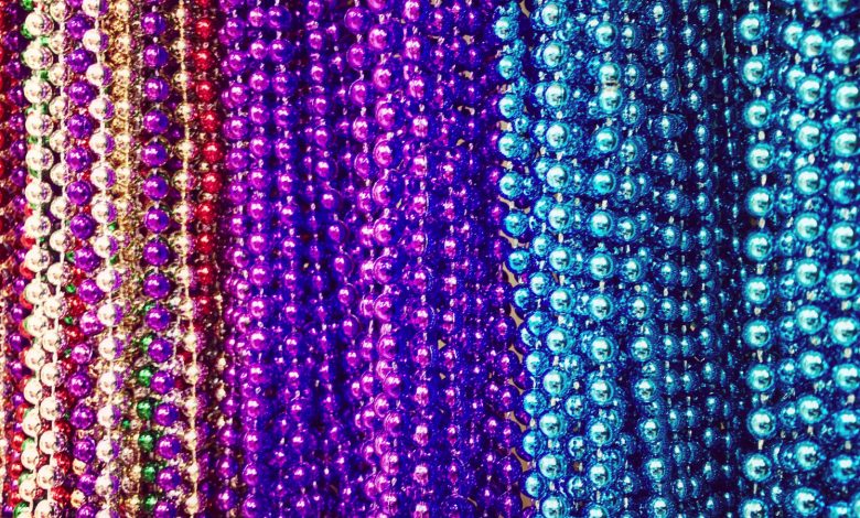 muitas contas de festa de plástico em várias cores, incluindo vermelho, roxo e azul.